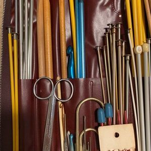 Large variety of knitting and crochet needles in zipper case.